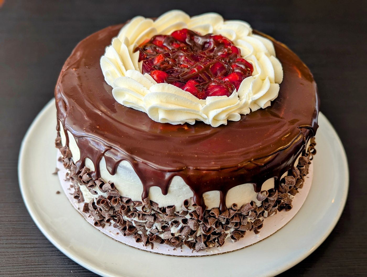 Whole black forest cake, chocolate glaze and cherries on top