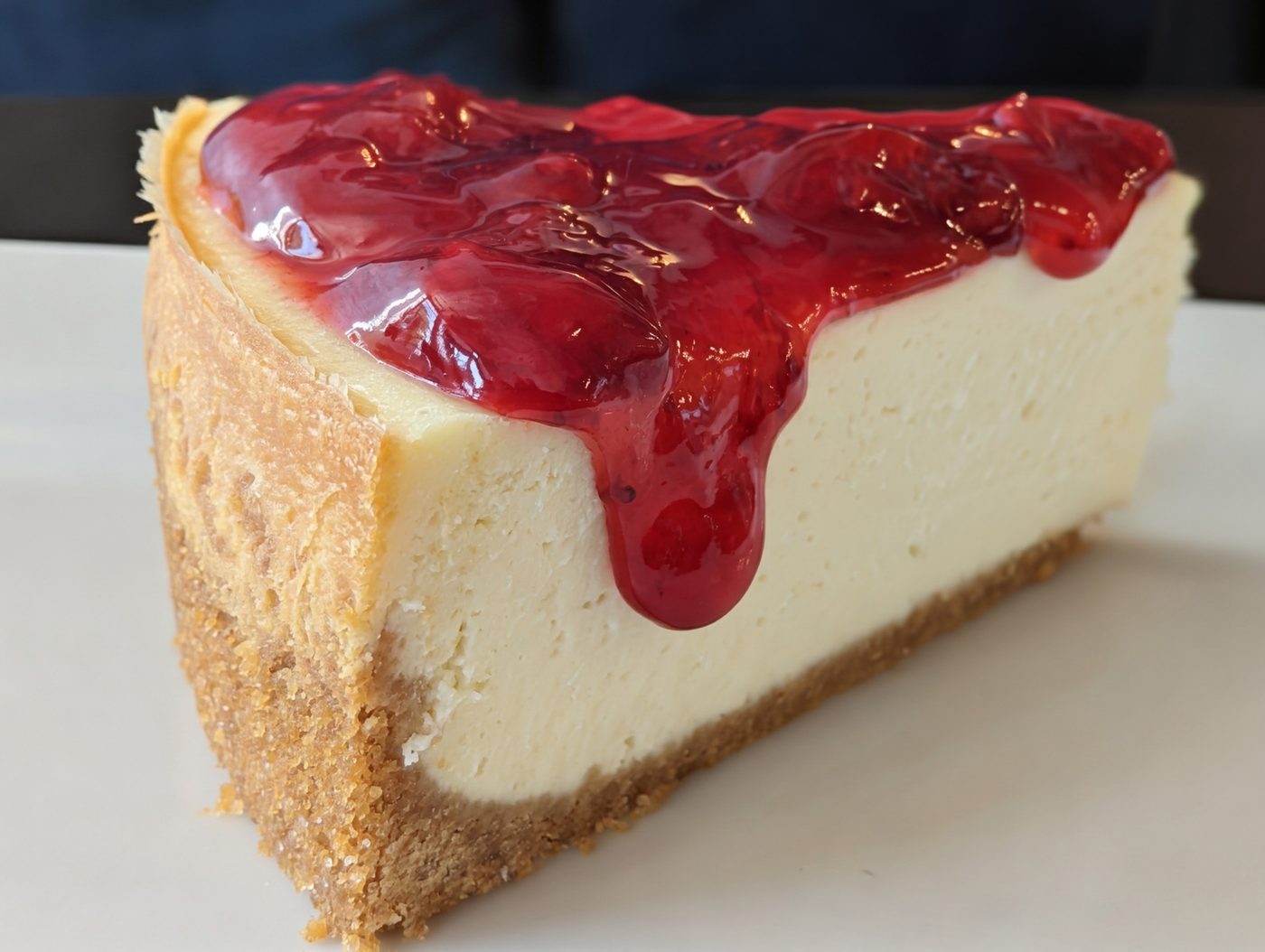 A slice of cheesecake with cherry topping